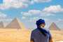 Turista apreciando as Grandes Pirâmides de Gizé