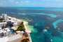 Vista aérea da zona hoteleira de Cancún com o mar, docas, barcos e catamarãs
